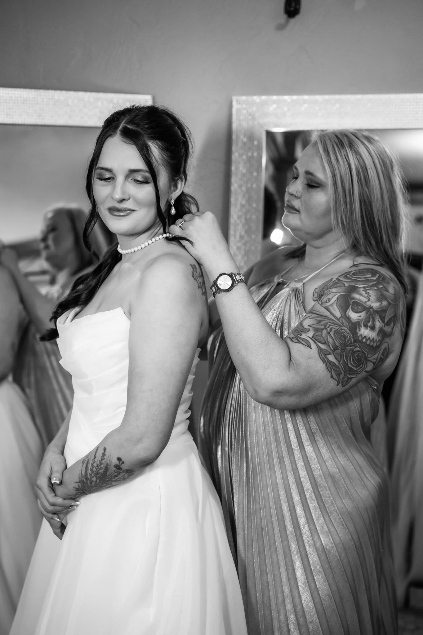 A loved one fastening the bride’s necklace in a Stone Ridge getting-ready room